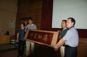 Alumni presenting tablet to their school Alumni presenting tablet to their school