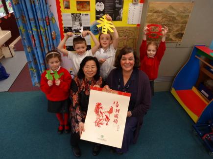 在小学的“中国新年文化墙”前赠送挂历